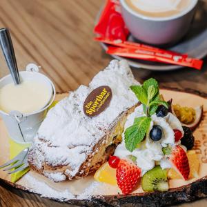 a piece of cake with fruit on a plate at Die Sportbar in Rio Bianco