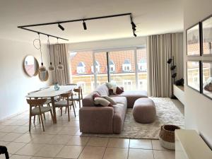 a living room with a couch and a table at Beachside Family Apartment Windstar 402 in Oostduinkerke