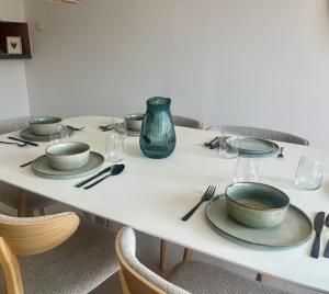 a white table with plates and vases on it at Beachside Family Apartment Windstar 402 in Oostduinkerke +17 photos