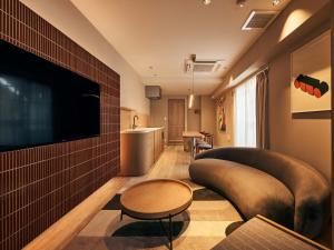 a living room with a couch and a flat screen tv at illi Mia Kinshicho in Tokyo