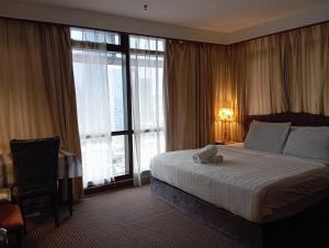a hotel room with a bed with a teddy bear on it at Service kl apartment times square in Kuala Lumpur +28 photos