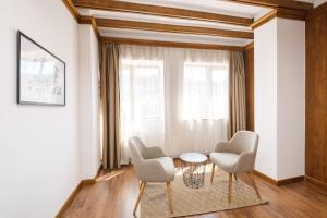 a living room with two chairs and a table and a window at Hotel Razlog in Razlog