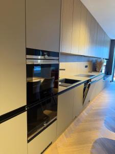 a kitchen with stainless steel appliances and wood cabinets at Apartmán MONTARA in Donovaly