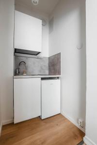 a kitchen with white cabinets and a sink at Elegantti yksiö keskustassa in Lahti