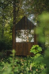 a wooden out house with a large window at Tiny-house PAMPA Lodges au bord de l'eau in Étival-lès-Le Mans