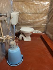 a bathroom with a toilet and a water cooler at Gowri Nature Stay Hampi in Hampi