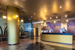 a lobby with a bar with purple walls and lights at Abba Garden in Barcelona