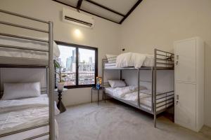 a bedroom with two bunk beds and a window at MornSamyan in Bang Rak