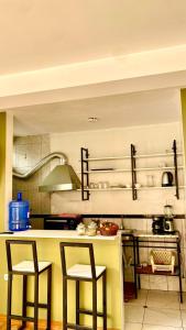 a kitchen with two bar stools and a counter top at Aqui y Ahora in Pisac