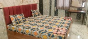a bedroom with a bed with a red head board at Hotel Ajanta Rekabganj Faizabad Ayodhya in Jāmb