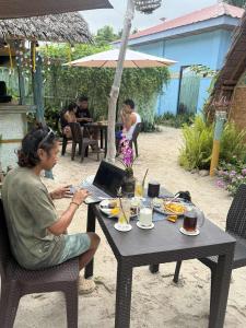 a woman sitting at a table with a laptop at Jonny's Hostel in San Juan +63 photos