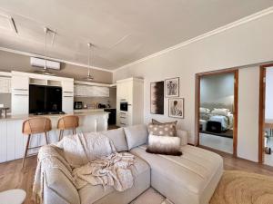 Una sala de estar con un sofá y una cocina. en Whispering Thorns Off-Site Apartment, en White River