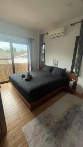 een slaapkamer met een groot bed met een groot raam bij Happy House in Chaloklum in Chaloklum