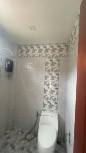 a bathroom with a toilet and a tiled wall at Happy House in Chaloklum in Chaloklum +14 photos