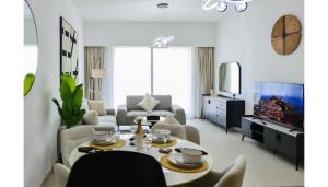 Una sala de estar con una mesa y un televisor. en Gate view Glow 1BR in Al Reem Island, en Abu Dabi