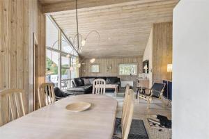 a kitchen and living room with a table and chairs at 1431-Aakirkeby-Strandvangen-13-B in Vester Sømarken