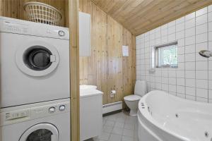 a bathroom with a washing machine and a tub at 1431-Aakirkeby-Strandvangen-13-B in Vester Sømarken +14 photos