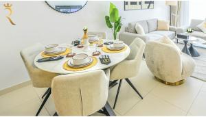 Un comedor con una mesa y sillas blancas. en Gate view Glow 1BR in Al Reem Island, en Abu Dabi