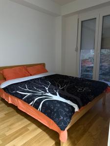 ein Bett mit einer schwarzen und weißen Bettdecke in einem Zimmer in der Unterkunft ViA prime central location in Ohrid