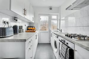 a white kitchen with a stove and a sink at 7 Beds, 4 Bedrooms, Parking, Close to Station in Parkside