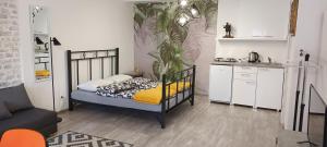 ein kleines Schlafzimmer mit einem Bett und einer Küche in der Unterkunft Flora Novi Sad in Novi Sad