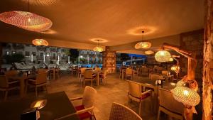 a restaurant with tables and chairs and lights at Casa De Levıssı Ölüdeniz in Oludeniz