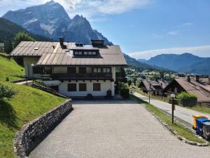 ein Haus auf einem Hügel mit Bergen im Hintergrund in der Unterkunft La Casa della Nonna in San Vito di Cadore