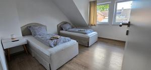 a room with two beds and a couch and a window at Komfort-Haus in Top-Lage in Osterholz-Scharmbeck