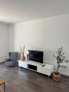 a living room with a flat screen tv on a white table at 'Casa Miliya' - Großzügiges Stadthaus mit Garten nähe Messe in Herford