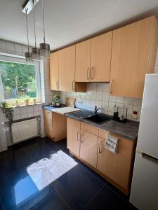 a kitchen with wooden cabinets and a sink and a window at 'Casa Miliya' - Großzügiges Stadthaus mit Garten nähe Messe in Herford