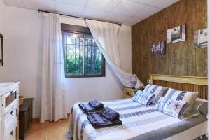 a bedroom with a bed and a window at Casa Rural La Atalaya in Castillo de Locubín +20 photos