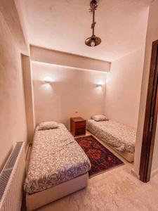 a bedroom with two beds and a rug at Veranda Villa in Arachova