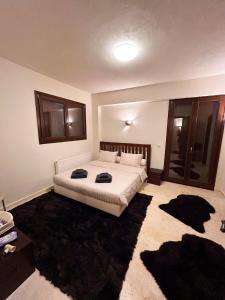 a bedroom with a large bed with black rugs at Veranda Villa in Arachova +9 photos