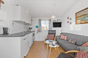 a small living room with a couch and a kitchen at 6630-Allinge-Madselokke-5-Hus-45 in Allinge +13 photos