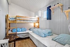 a bedroom with two bunk beds with blue pillows at 6630-Allinge-Madselokke-5-Hus-45 in Allinge