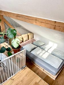 a bed in a room with pillows and plants at Barn Apartment in an Old Farmhouse near Vaduz in Sevelen