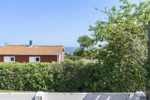 a house on a hill with trees and a fence at 6630-Allinge-Madselokke-5-Hus-45 in Allinge