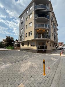 ein hohes Gebäude mit einem gelben Mast davor in der Unterkunft ViA prime central location in Ohrid