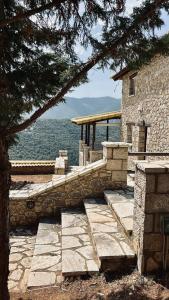 un edificio de piedra con vistas al agua en Veranda Villa, en Arachova