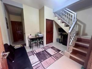 a living room with a staircase and a desk at Ace Transient in Puerto Princesa City