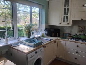 a kitchen with a sink and a washing machine at The Peak Retreat in Longdendale