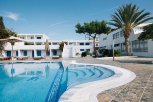 a swimming pool in front of a building at Lagada Beach Hotel in Adamantas