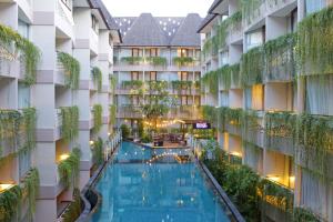 an indoor pool in the courtyard of a hotel at Episode Kuta Bali in Kuta