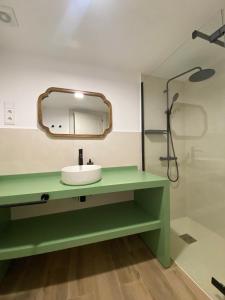 a bathroom with a green sink and a mirror at El Molino del Burgo de Osma in El Burgo de Osma