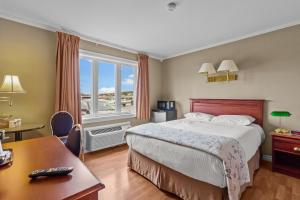 a hotel room with a bed and a desk and a window at Bayview Inn in Bay Roberts