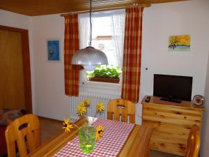 a dining room with a table and a television at Gästehaus Brigitte Kienzler in Gremmelsbach