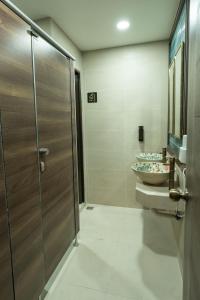 a bathroom with two sinks and a glass shower stall at Soultel โซลเทล in Khlong San +32 photos