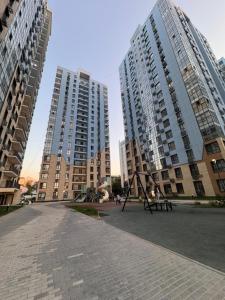 two tall buildings with a park with a swing at 2 room apartment, ЖК Кристалл in Almaty