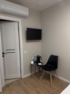 a room with a chair and a television on the wall at Meraki Residence in Ungheni +5 photos