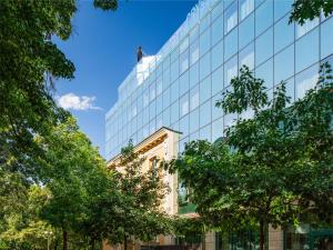 a glass building with trees in front of it at Crystal Palace Boutique Hotel in Sofia